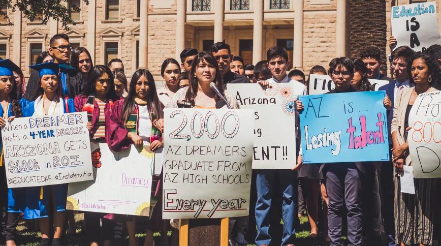 A group of young people hold up signs advocating for the rights of undocumented people in the US