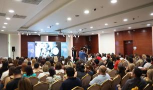 A large crowd watches a film in an auditorium