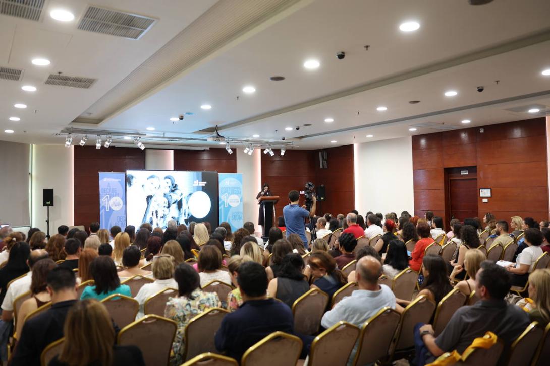 A large crowd watches a film in an auditorium